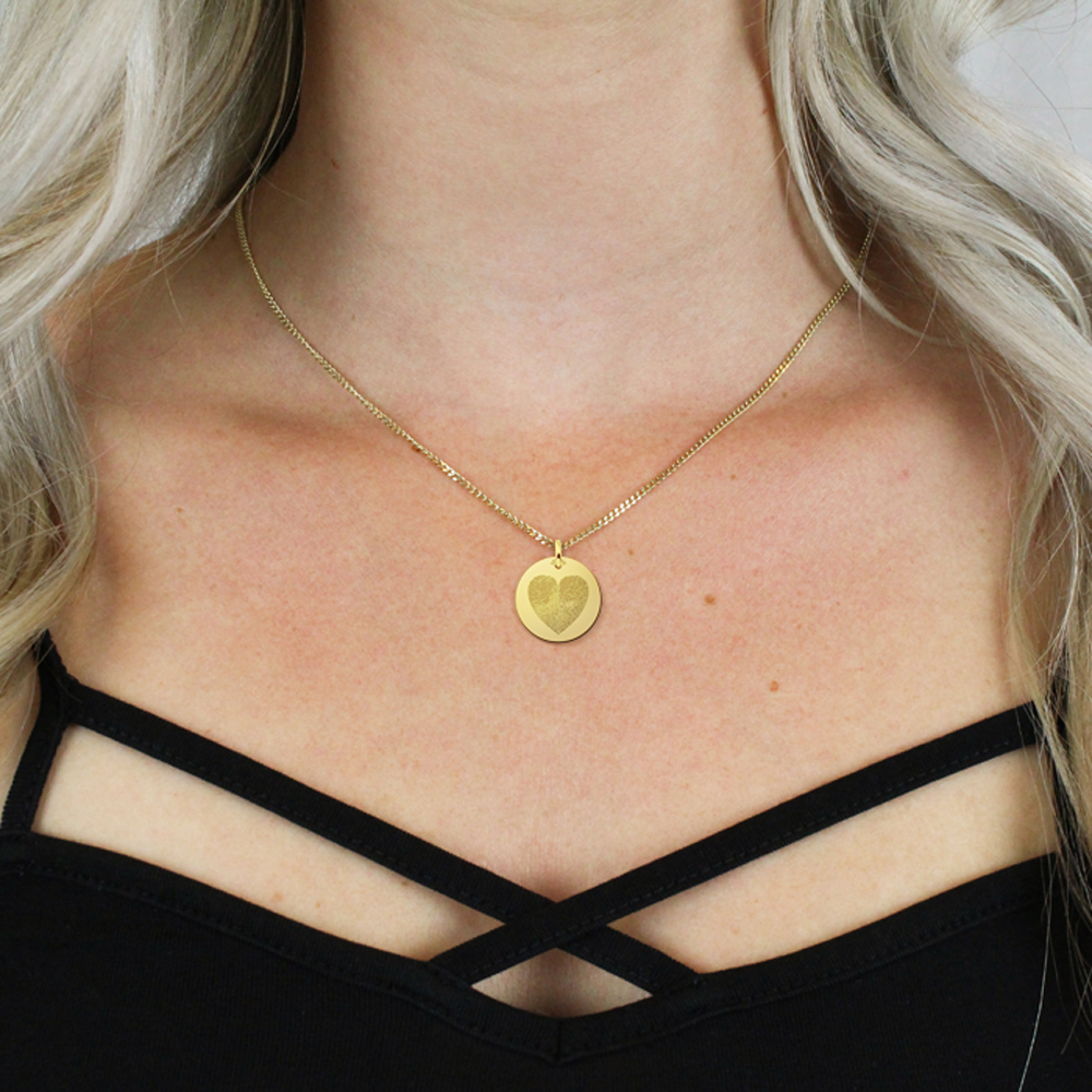 Golden pendant with two fingerprints in heart shape