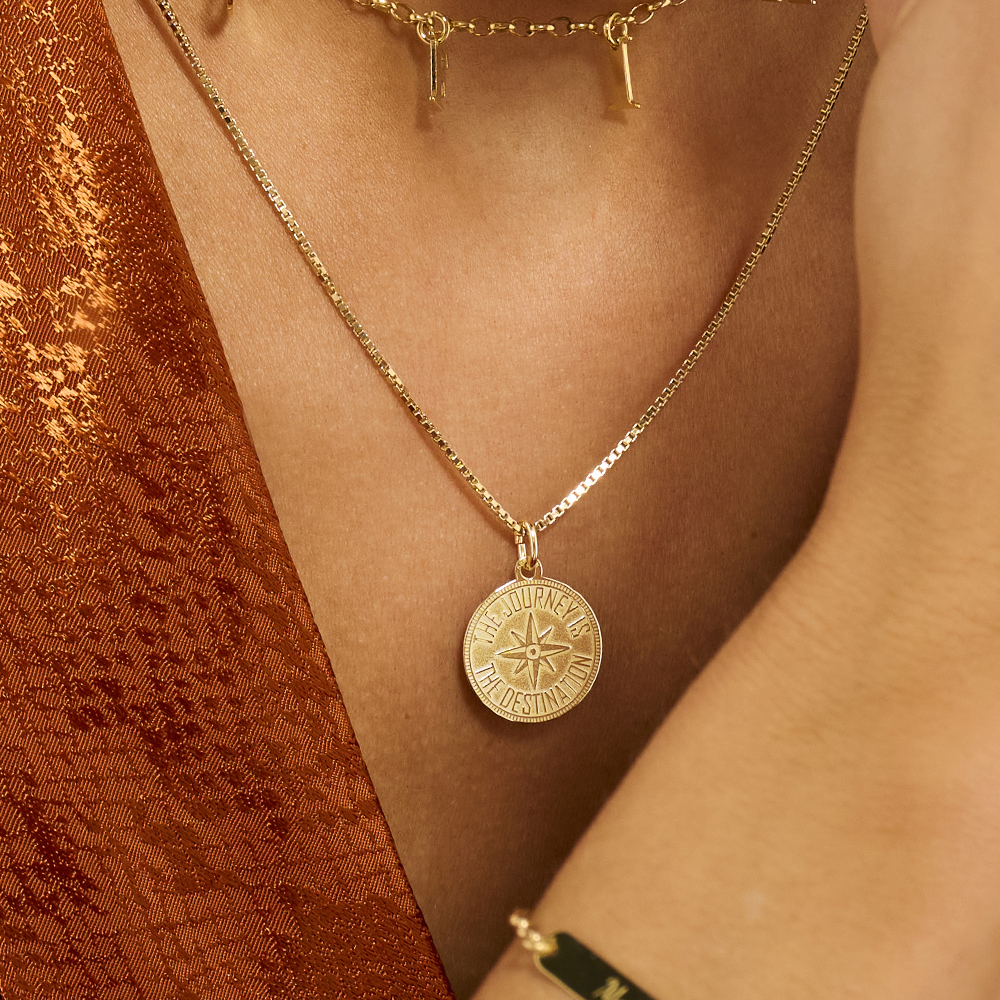 Gold coin pendant met compas and engraving