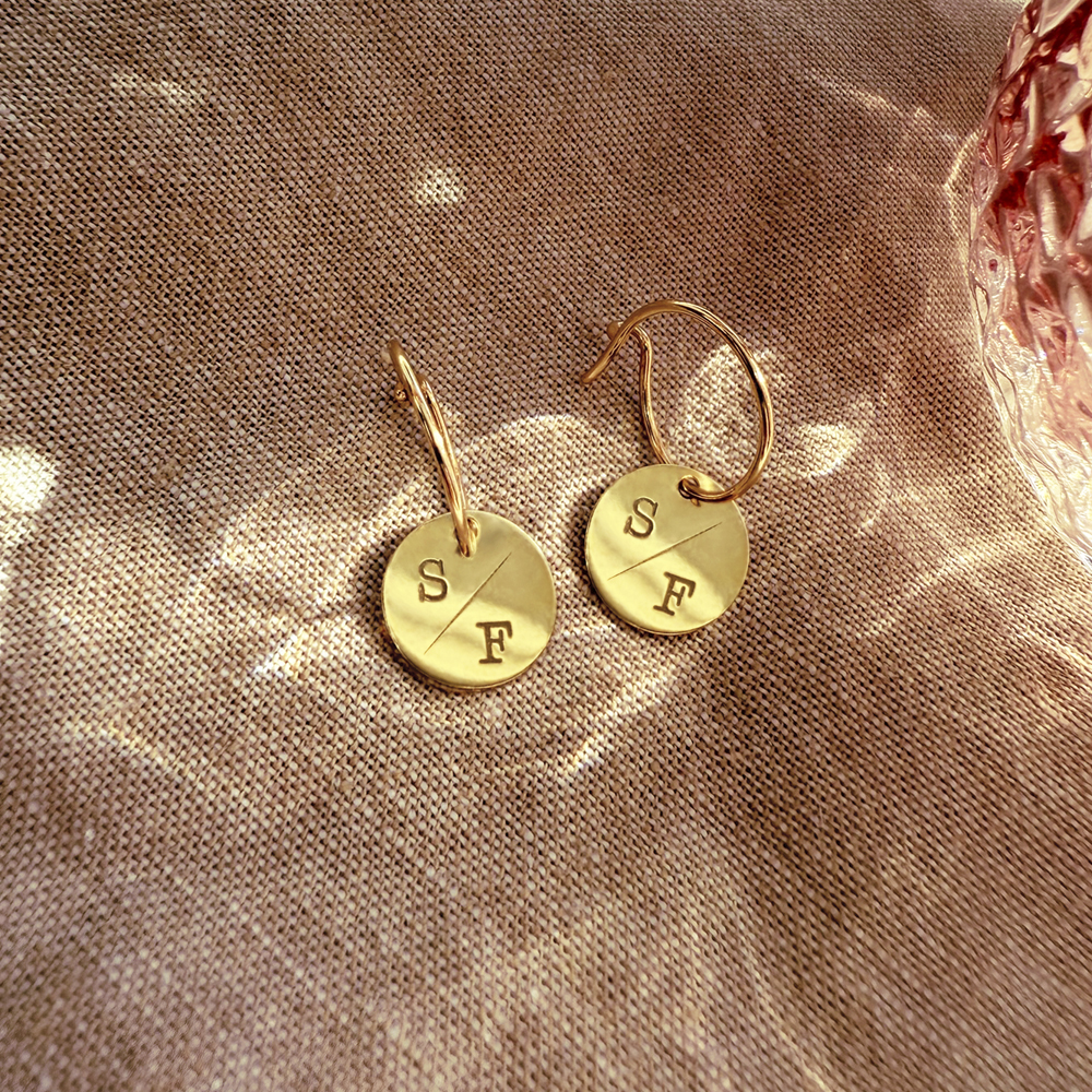 Gold earrings with round pendant and initials