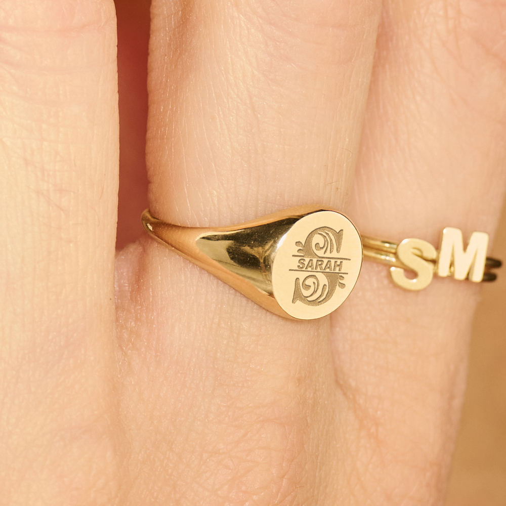 Round gold signet ring with an initial an a name