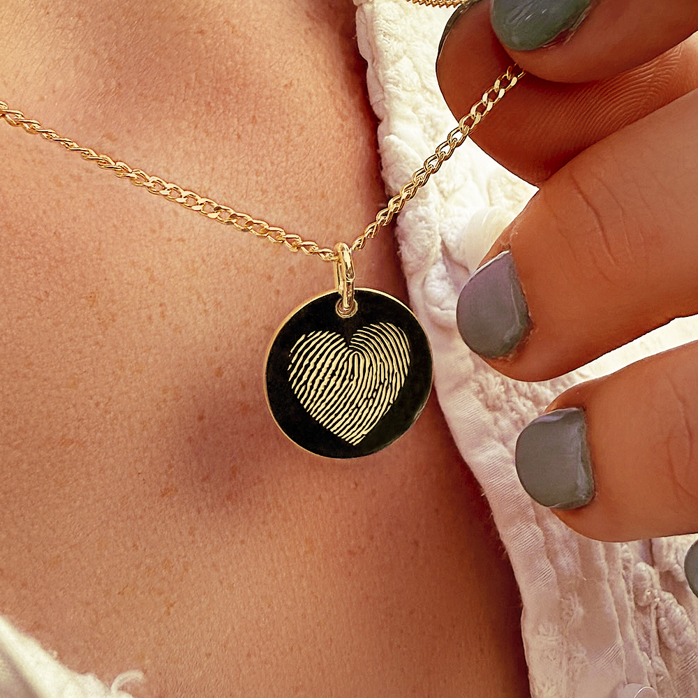 Golden pendant with fingerprint in heart shape