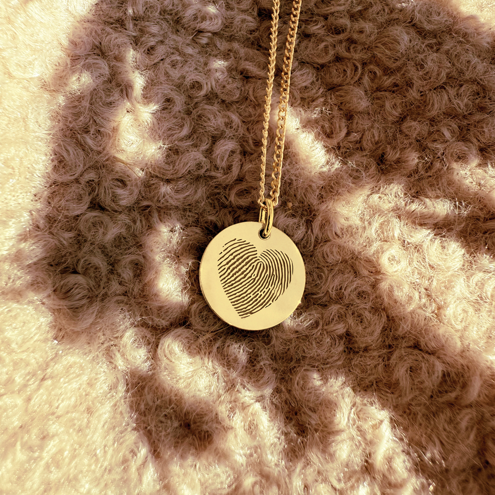 Golden pendant with fingerprint in heart shape